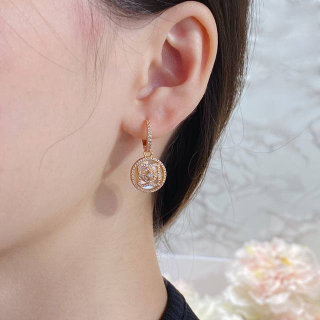 V gold material. De Beers high-end mother-of-pearl lotus earrings, set against t