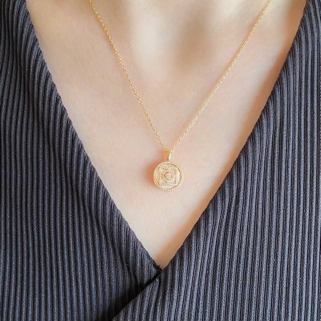V gold De Beers high-grade mother-of-pearl lotus necklace, set against the spark