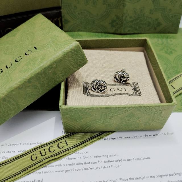 GucciThese earrings feature a twisted ribbon design with a double G motif. This