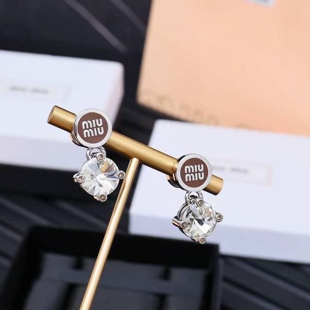 Miumiu enamel button large diamond earrings. Miumiu's logo design elements are m