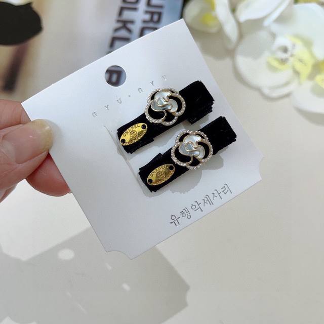 comes with a pair of Chanel's new Chanel-style camellia Bb clips, classic lette