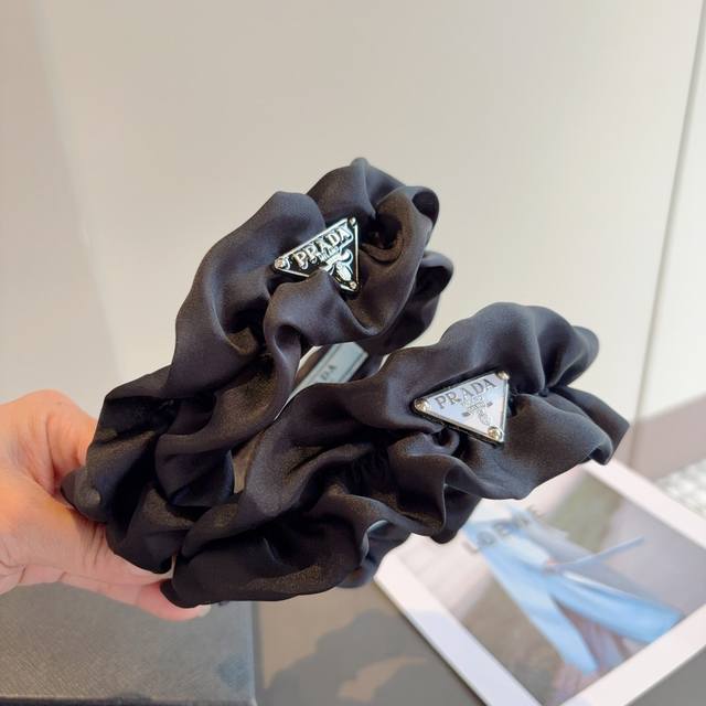 with packaging Prada's new trendy pleated triangle logo headband. A must-have f
