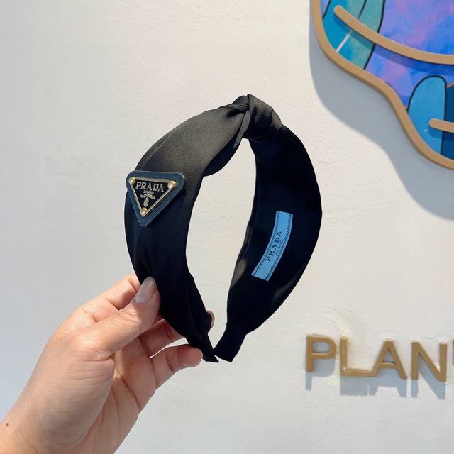 with packaging Prada's new inverted triangle headband with lettering. A must-ha
