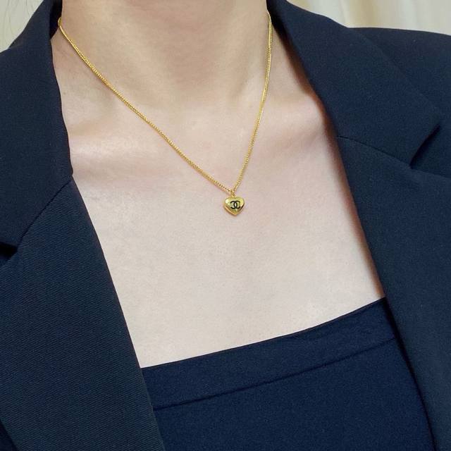 Chanel's latest double C necklace is a stylish, retractable, antique gold heart-