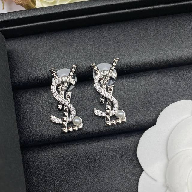 Ysl's classic luxury silver earrings are as stylish and versatile as a cocktail