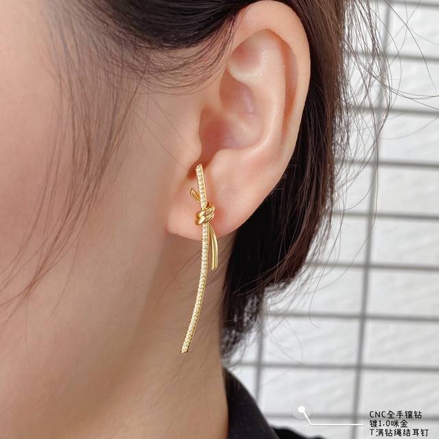 This price-adjusted V-gold earring is made of Zp open-edition. The intertwined e
