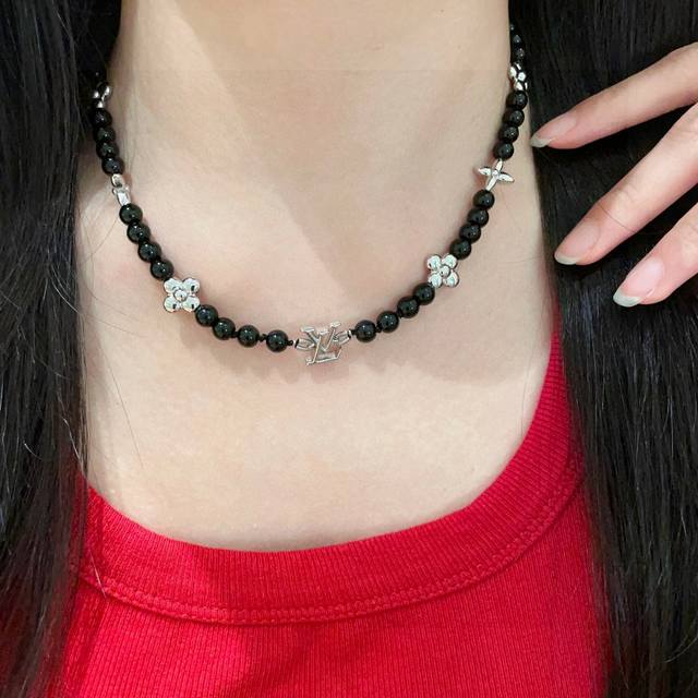 This Louis Vuitton pendant features a classic floral motif and a double flower d