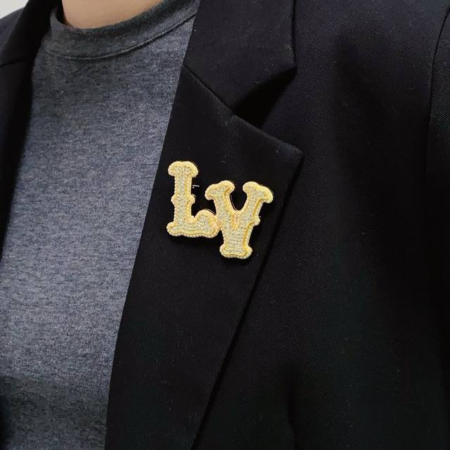 Louis Vuitton's new gold brooch with diamond letters and small pearls. Lv is the