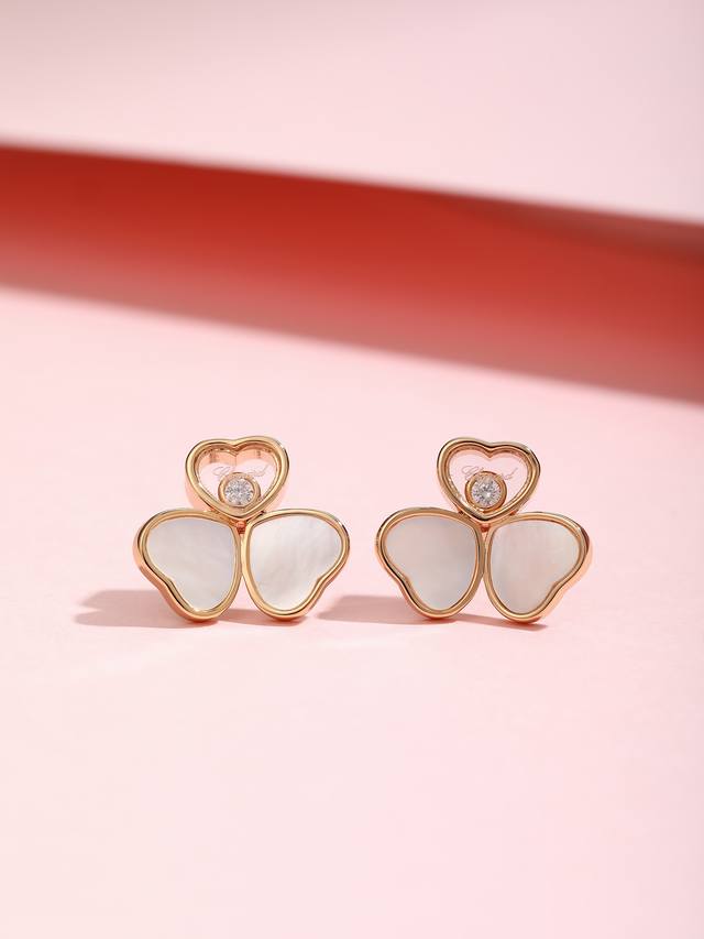 Two mother-of-pearl hearts, arranged like butterfly wings, hang atop a heart inl