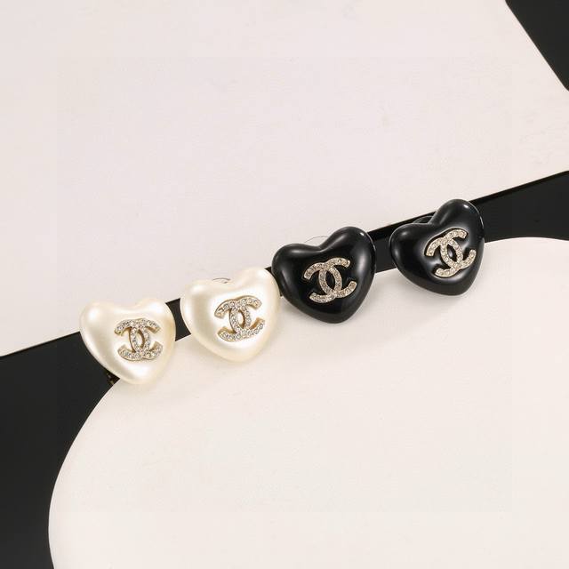 Chanel heart-shaped stud earrings, flattering the face shape. The gold metal tri