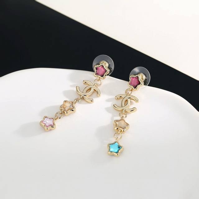 Chanel's new star-patterned long stud earrings flatter the face. The gold metal