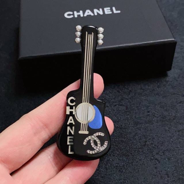 This latest high-quality imported acrylic guitar-shaped brooch with diamond embe