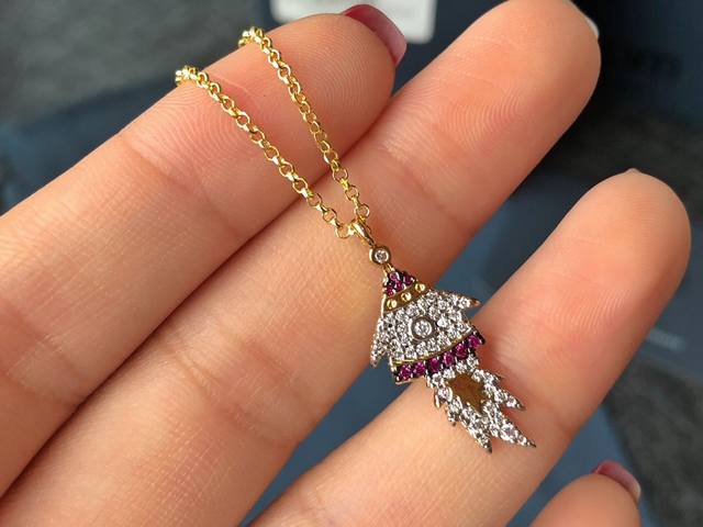 A batch of Monaco gold-plated diamond-encrusted rocket spaceship pendant necklac