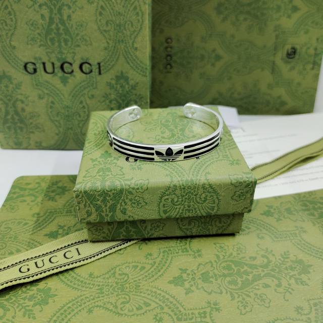 One of the new Adidas X Gucci collaboration bracelets features a Trefoil and thr
