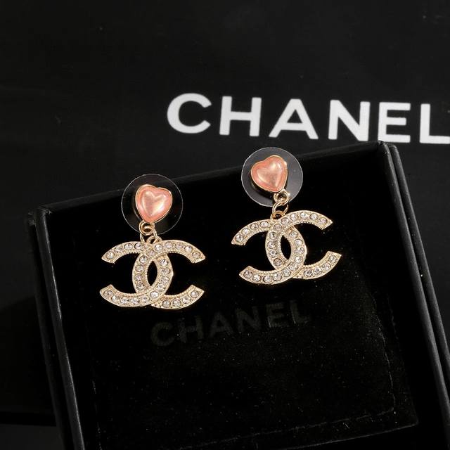 Chanel heart-shaped stud earrings, flattering the face shape. The gold metal tri