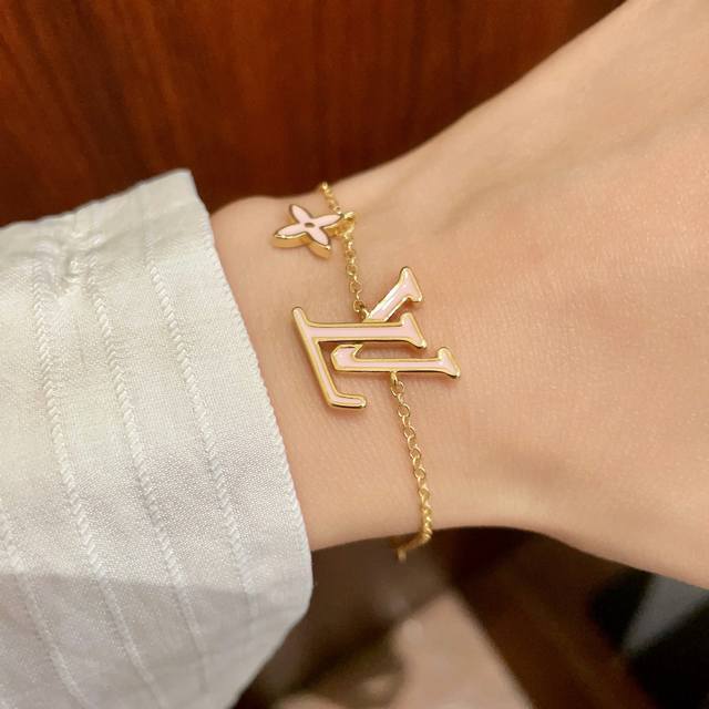 This Louis Vuitton pendant features a classic double-flower pattern and the LV b