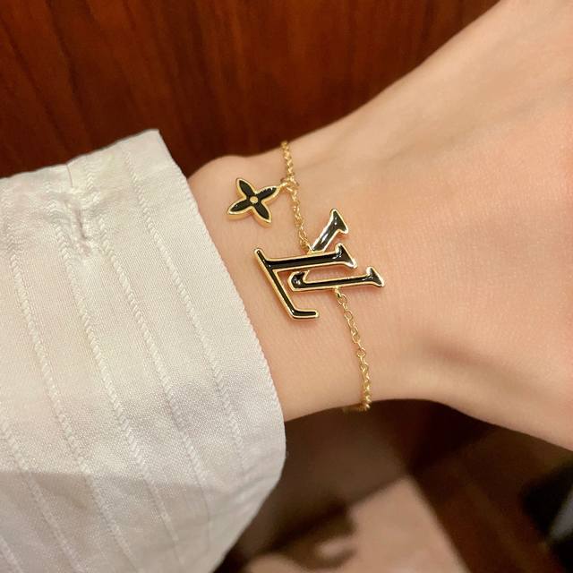 This Louis Vuitton pendant features a classic double-flower pattern and the LV b