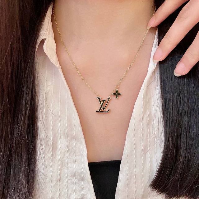 This Louis Vuitton pendant features a classic double-flower pattern and the LV b