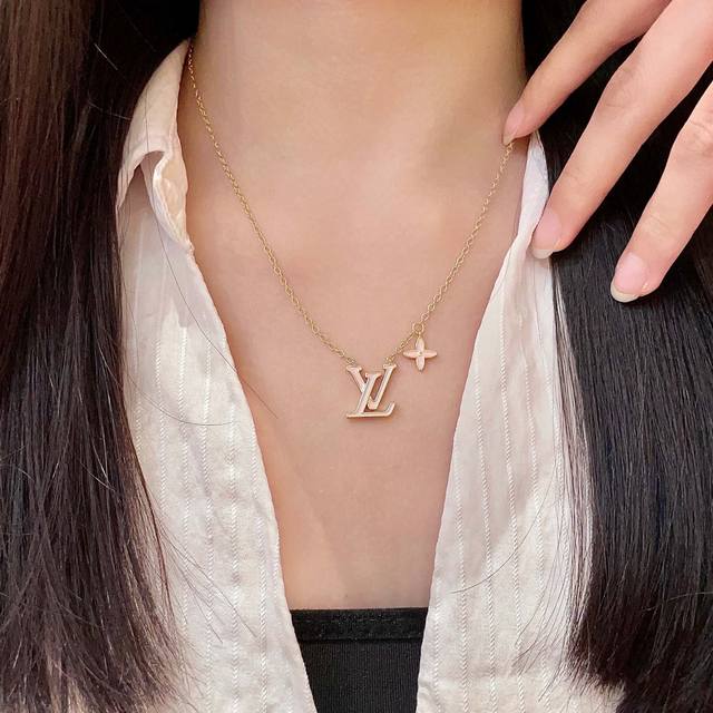 This Louis Vuitton pendant features a classic double-flower pattern and the LV b