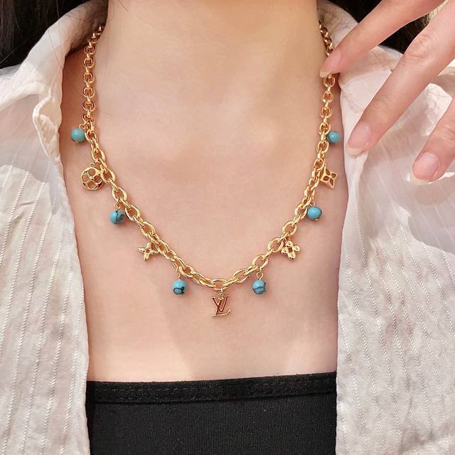 This Louis Vuitton pendant features a classic double-flower pattern and the LV b