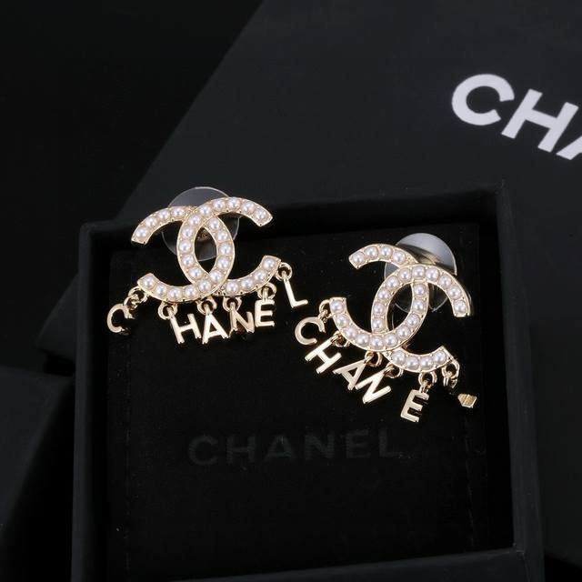 Chanel stud earrings are subtly placed on either side of the earlobe, simple yet