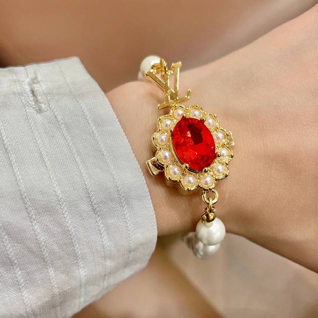 This Louis Vuitton pendant features a classic double-flower pattern and the LV b