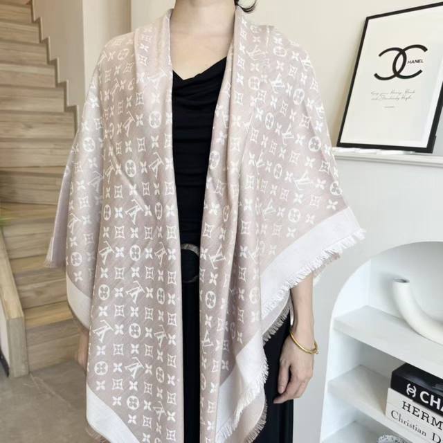 This square scarf/shawl from Lv features classic gold thread paired with a luxur