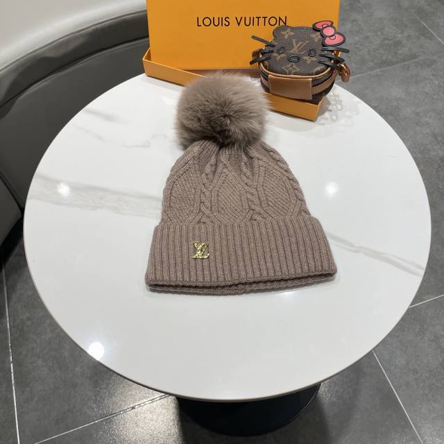 This beanie features a classic cable knit design with a gold LV logo. Made with