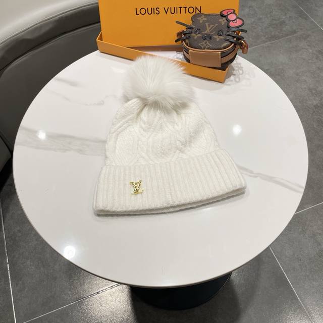 This beanie features a classic cable knit design with a gold LV logo. Made with