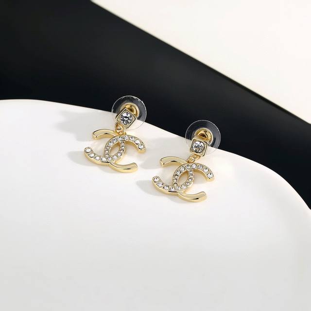 Chanel stud earrings flatter the face shape. The gold metal trim gives them a m