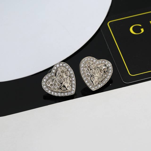 Chanel heart-shaped stud earrings, further enhancing the face shape. The gold m