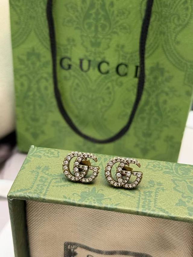 Gucci classic GG logo earrings, featuring gold-plated metal and a full diamond d